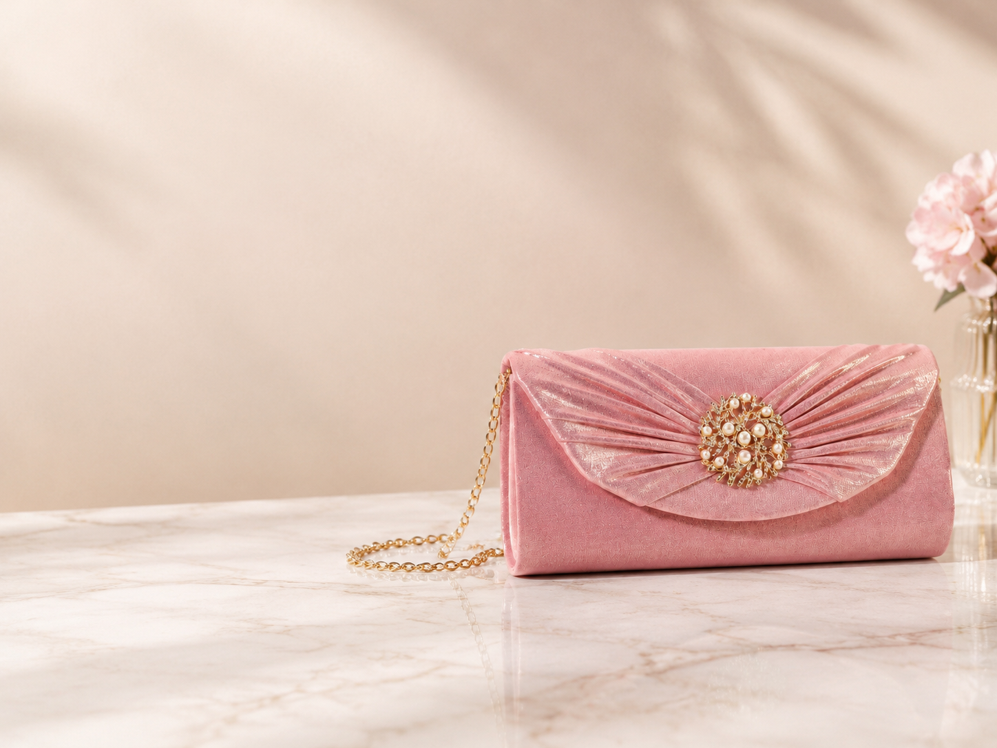 Pink pleated evening clutch with gold pearl brooch and chain
